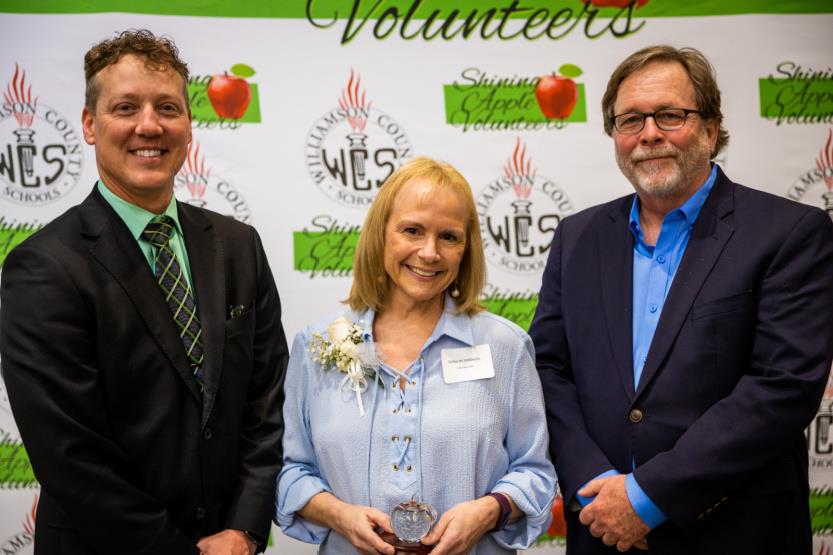 Two men and a woman pose for a photo